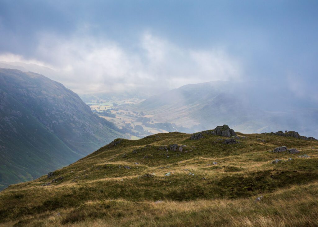 Lake District landscape photography from Bowfell during blue hour near The Band. Mickleden Valley is briefly visible during a gap in the clouds during the later stages of blue hour.