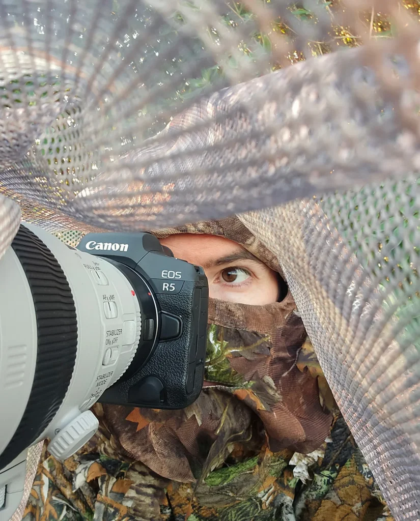 An example of nature photography fieldcraft, showing photographer Simon Evans hidden under a makeshift hide.