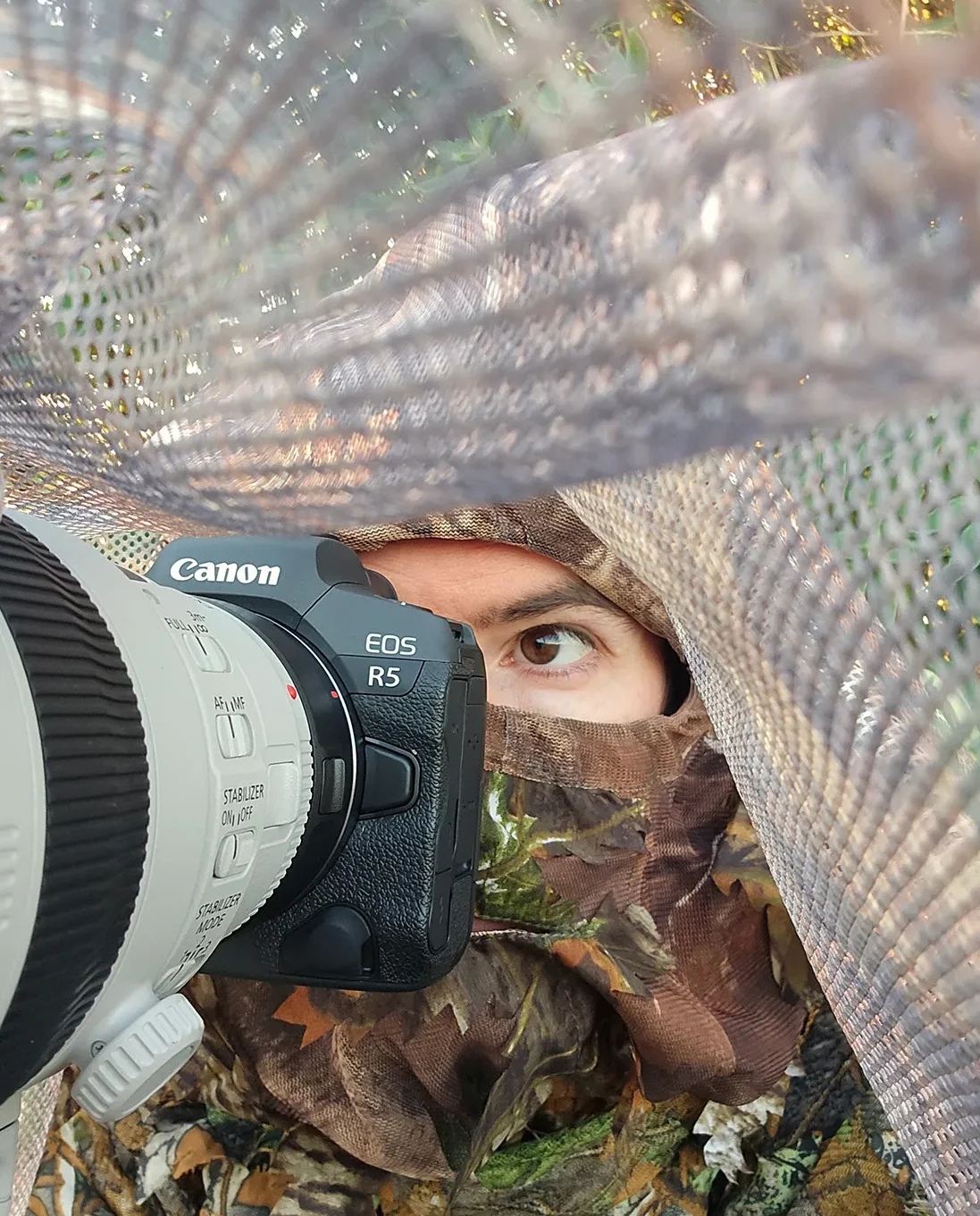 An example of nature photography fieldcraft, showing photographer Simon Evans hidden under a makeshift hide.