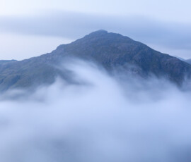 Landscape photograph of Pike of Blisco surrounded by a blanket of cloud as a temperature inversion builds during blue hour in the Lake District.