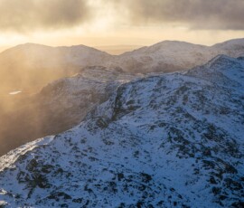 Breathtaking full winter conditions on Crinkle Crags and Cold Pike in the Lake District during a spectacular sunrise.