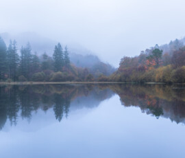 Beautiful autumn reflections across Yew Tree Tarn near Coniston in the early hours of the morning.