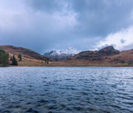 Storm Barra making an appearance over Blea Tarn in the Lake District. Stormy waters and a snow-covered Langdale Pikes in the distance.
